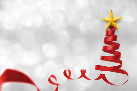 Christmas tree made of red satin ribbon scroll with gold star isolated on white silver snow background with clipping path for winter xmas holiday greeting card design arts elementの写真素材
