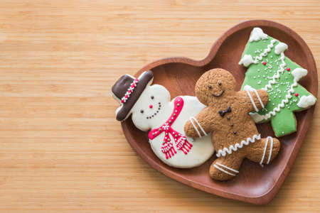 Christmas cookies, snowman, X'mas tree, gingerbread flat lay on wooden cutting board background top view for Xmas party holiday food design decoration backdropの写真素材