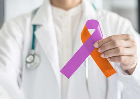 Psoriasis illness and Eczema Dermatitis skin disease awareness campaign concept with orchid purple orange ribbon symbolic bow color on doctor's hand supportの写真素材