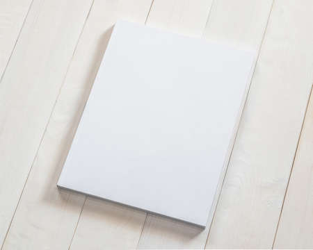 Blank book cover mockup template with page front side on white surface on wood tableの写真素材