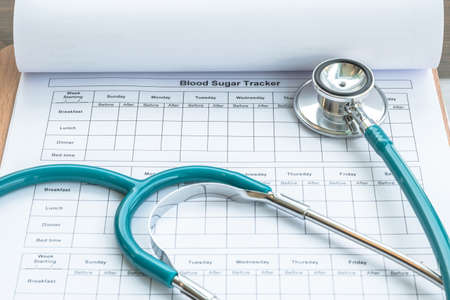 World health diabetes day concept with blood sugar monitoring record and doctor's stethoscope