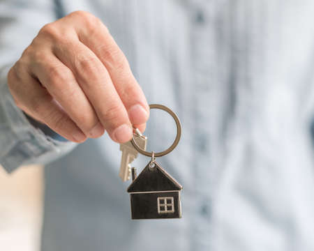 House key in real estate sale person, landlord or home Insurance broker agent's hand giving to buyer...