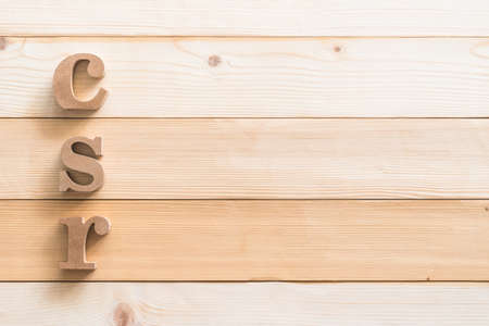 CSR (Corporate social responsibility) abbreviation wood letters on natural white wooden background for business vision concept backdropの写真素材