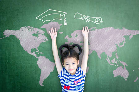 Scholarship opportunity and education success concept with school kid with doodle drawing of graduation cap on green chalkboardの写真素材