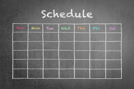Schedule with grid timetable on black chalkboardの写真素材