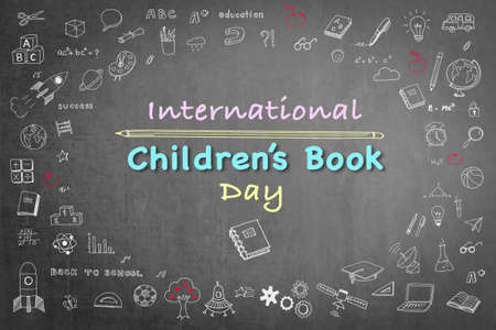 International Children's Book day greeting with doodle on grunge black chalkboardの写真素材