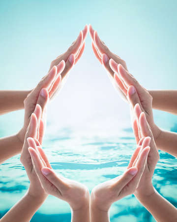 Saving water clean natural environment ocean campaign concept with collaborative woman's hands in droplet shape on blurred wavy clean water backgroundの写真素材