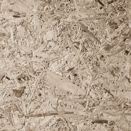 Chipboard, OSB -Oriented strand board particle pressed recycled wood panel background with grainy wooden fiber pattern backdrop in natural beige brown colorの写真素材