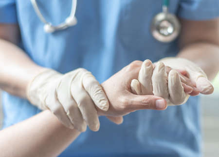 Surgeon, surgical doctor, anesthetist or anesthesiologist holding patient's hand for health care trust and support in professional ER surgical operation, medical anesthetic safety, healthcare conceptの写真素材
