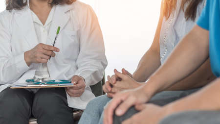 Patient couple having doctor or psychologist consulting on marriage counseling, family medical healthcare therapy, IVF insemination fertility treatment for infertility or psychotherapy session conceptの写真素材