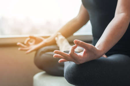 Yoga with woman person in lotus pose meditating in relax silence gym class or home indoor in the morningの写真素材