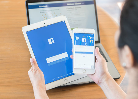 BANGKOK, THAILAND - October 23, 2017: Facebook social media app logo on log-in, sign-up registration page on mobile application screen on iPhone smart devices in working womanâs handのeditorial素材