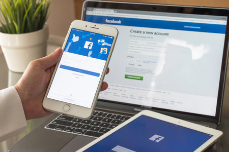 BANGKOK, THAILAND - July 6, 2017: Facebook social media app logo on log-in, sign-up page on mobile app screen on iPhone smart devices in business person's handのeditorial素材