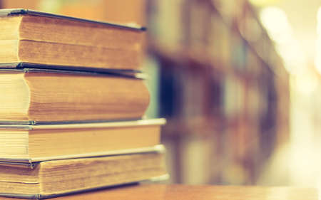 Book stack in library study room with bookshelf for business and education background, class learning and back to school conceptの写真素材