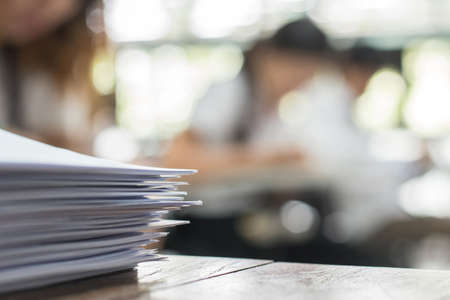 Exam answer sheet or application paper blurry view on table in examination room with blur education...