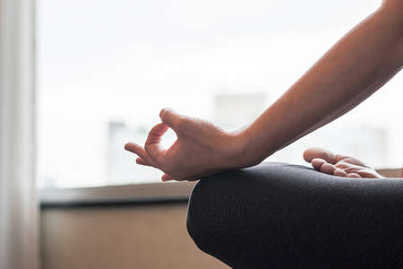 Woman relaxing in yoga lotus pose meditating in silence gym class or home indoorの写真素材