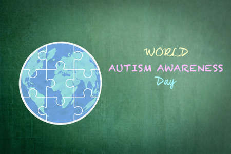 World Autism Awareness day with doodle of globe in puzzle jigsaw piece on school green chalkboardの写真素材