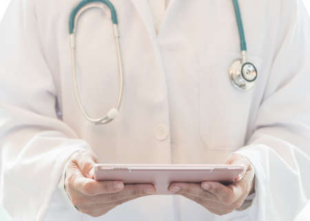 Medical doctor or physician with tablet for patient's health record in hospital or clinicの写真素材
