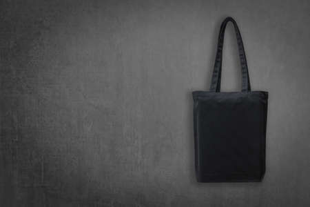 Black Eco cotton tote bag mock up shopping fabric cloth sack with handle on blackboard background for mockup design backdrop template and go green conceptの写真素材