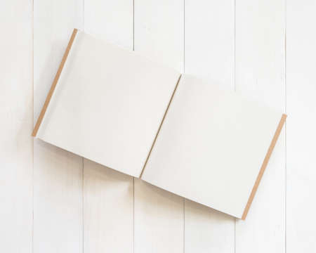 Blank book mockup open page template square-size recycle paper texture on white wood tableの写真素材
