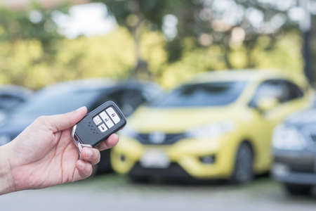 Car valet parking service business concept with people handling car key on blur parking lot...
