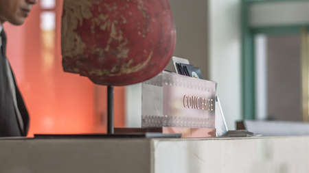 Concierge service desk counter with hotel staff team working in front of reception hall for tourist business customerの写真素材