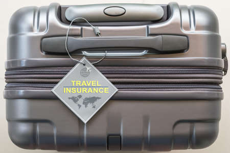 Travel insurance protection plan for airline safety and security with tag on passenger suitcase luggage handleの写真素材