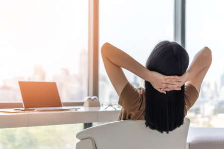 Life quality, living balance and carefree mental health concept with young woman take it easy working and resting in luxury business city hotel or at home office with computer pc laptop on deskの写真素材
