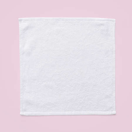 White cotton towel mock up template square size fabric wiper isolated on pastel pink background with clipping path, flat lay top viewの写真素材