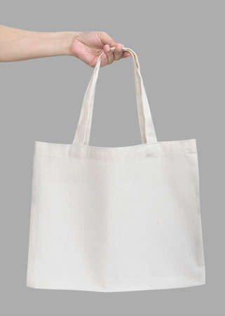 Tote bag canvas white cotton fabric cloth eco shopping sack mockup blank template isolated on grey background (clipping path) with womanâs handling handの写真素材