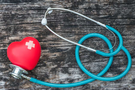 Healthcare insurance and world health day concept with red heart love with cross bandage and medical doctor physician's stethoscopeの写真素材