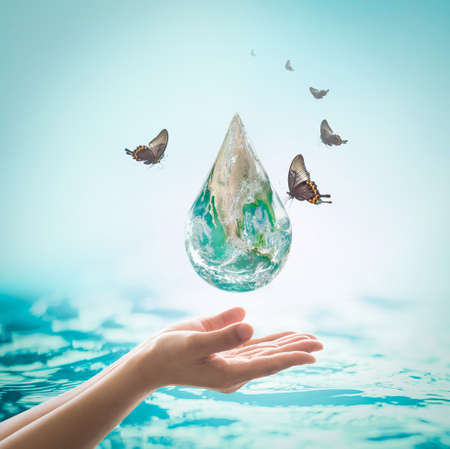 World ocean day,, saving water campaign, sustainable ecological ecosystems concept with green earth on woman's hands on blue sea backgroundの写真素材