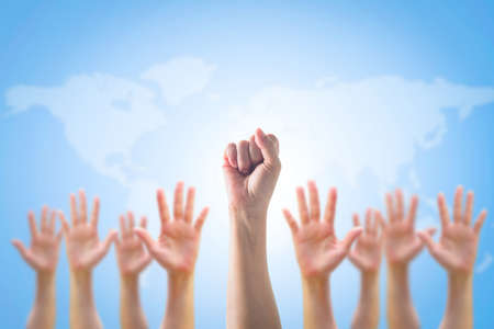 Empowering women power, human rights and labor day concept with strong fist hands and world map backgroundの写真素材