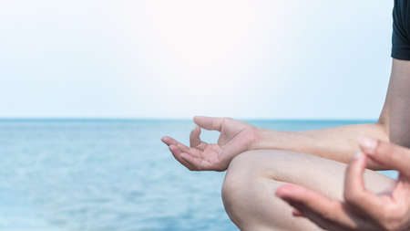 Mantra yoga meditation, spiritual mental health practice with woman in lotus pose having peaceful mind relaxation on the beach outdoor training with cool morning skyの写真素材