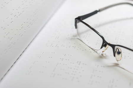 Braille book for low vision/ blind person reading the sign, eyeglasses background.の写真素材