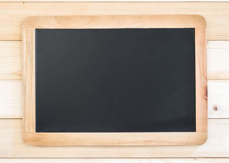 Blank black chalkboard frame with copyspace hanging on pine wood wall for announcement and...