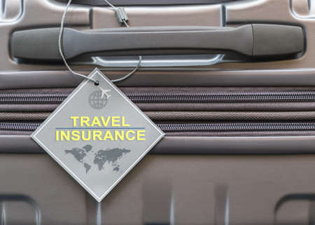Travel insurance protection plan for airline safety and security with tag on passenger suitcase luggage handleの写真素材
