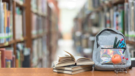 Back to school concept with school books, textbooks, backpack and stationery supplies on classroom desk with library or class background for educational new academic year begin or study term startの写真素材