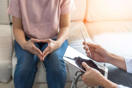 Menopause woman, stressful patient consulting with doctor or psychiatrist who diagnostic examining on obstetric - gynaecological female illness, or mental health in medical clinic or hospitalの写真素材