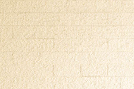 Limestone rock slab tile wall texture patterned background in light pastel cream yellow beige colorの写真素材