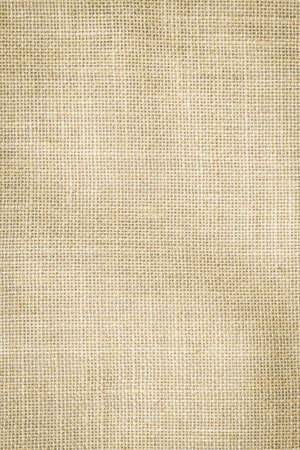 Hessian sackcloth woven texture pattern background in light cream yellow beige earth tone colorの写真素材