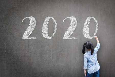 2020 Happy new year school class academic calendar with student kid's hand drawing greeting on teacher's chalkboard for educational celebration, classroom schedule conceptの写真素材