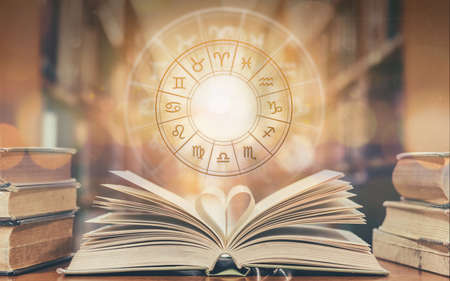Love horoscope, zodiac sign astrology for foretell and fortune telling education study course concept with horoscopic wheel over old love story book in school libraryの写真素材
