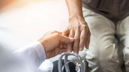 Parkinson's disease patient, Arthritis hand pain or mental health care concept with geriatric doctor consulting examining elderly senior aged adult in medical exam clinic or hospitalの写真素材