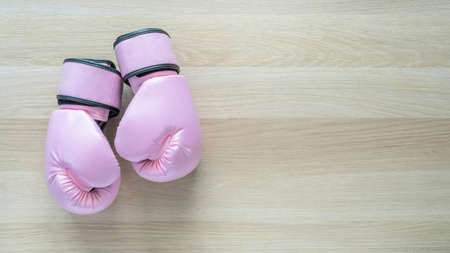 Pink boxing gloves for girl and woman sports fight and recreational exercise on white wood background with copy spaceの写真素材