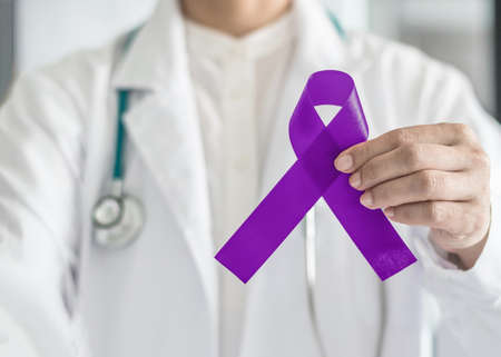 Plum purple ribbon for raising awareness on Alzheimer's disease, breastfeeding, eating disorder, national family caregivers month and epilepsy illness with bow in doctorâs hand supportの写真素材
