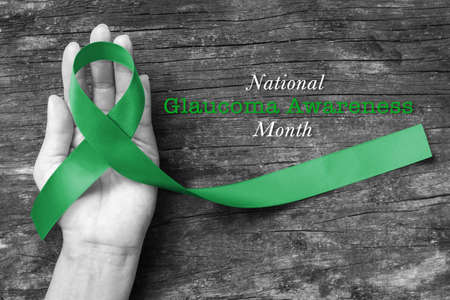 National Glaucoma Awareness Month in January with Green ribbon on helping hand (bow isolated with clipping path)の写真素材