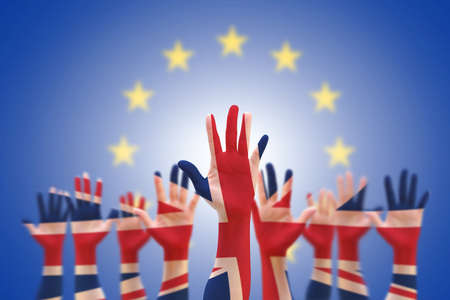 United kingdom (UK) flag pattern on people participation hands and EU European flag on blue sky  backgroundの写真素材