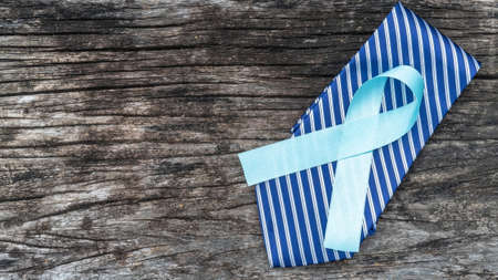 Blue awareness ribbon for prostate cancer, men health in November with light blue bow color on medical doctor record, male patient healthcare conceptの写真素材