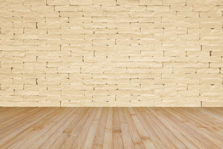 Grunge brick wall painted in light yellow beige with wooden floor in yellow brown for interior backgroundsの写真素材
